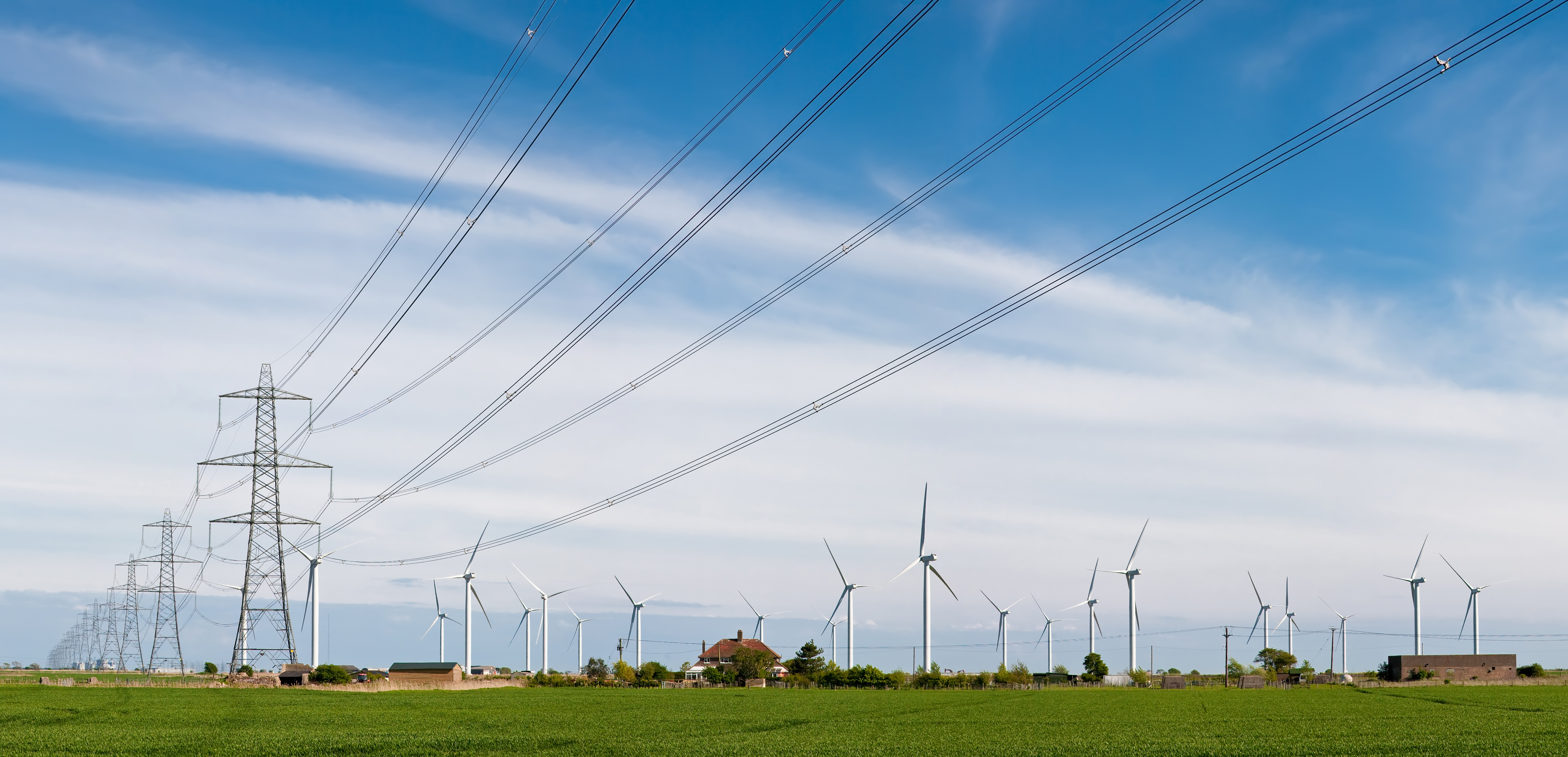 Wind turbines and power lines at sunset
